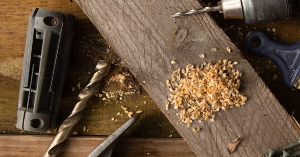 Drill bits, screws and wood shavings arranged on a timber workbench