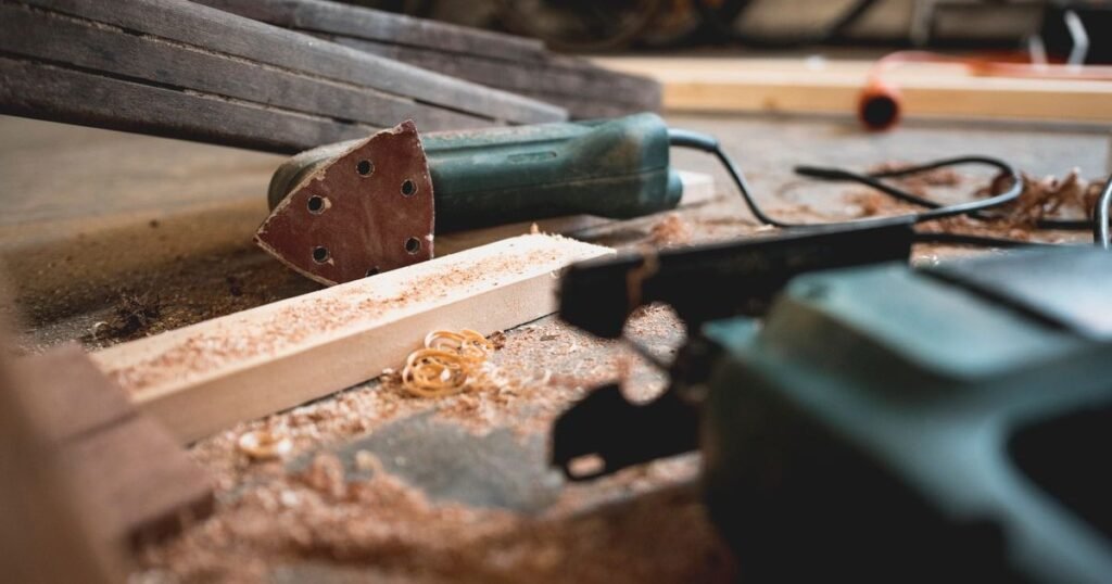 Cordless multi-tool and sawdust on a workshop bench